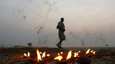 Un peregrino hindú camina junto a una hilera de lámparas encendidas después de tomar un baño sagrado en la confluencia de los ríos Ganges y la Bahía de Bengala en Sagar Island. REUTERS/Rupak De Chowdhuri