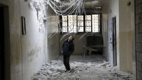 Un niño inspecciona los daños dentro de su escuela hechos por lo que denuncian los activistas como un ataque aéreo llevado a cabo ayer por la Fuerza Aérea rusa en la ciudad Injara, Alepo, Siria./ REUTERS / Khalil Ashawi