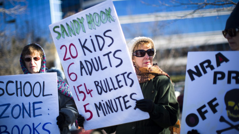 Decenas de personas se manifiestan frente a la sede de la Asociación Nacional del Rifle (NRA) para pedir un mayor control sobre la venta de armas en Fairfax, Virginia, Estados Unidos, hoy 14 de enero de 2016. EFE/Jim Lo Scalzo