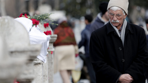 Una hombre deposita flores en la explanada de Sultanahmet, situada ante la Mezquita Azul en Estambul donde un terrorista suicida del grupo terrorista Estado Islámico (Dáesh) se inmoló y mató a 10 turistas, entre ellos ocho alemanes y un per