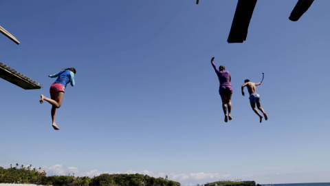 Unos turistas saltan al agua desde una de los islotes de la Isla de Boracay (Islas Filipinas) a 20 metros de altura. REUTERS/Charlie Saceda