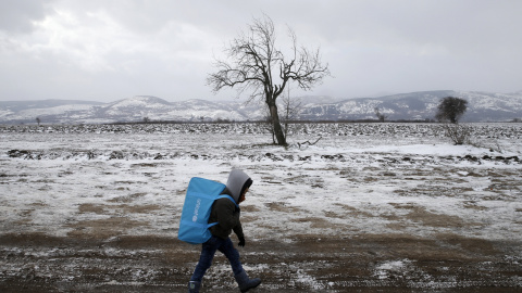 Un niño refugiado camina a través del campo cubiero de nieva hacia Macedonia. Cerca del pueblo de Miratovac, Serbia. REUTERS/Marko Djurica