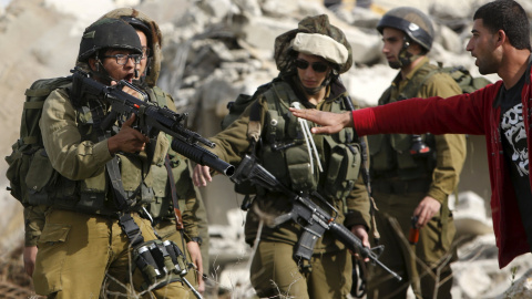 Un palestino discute con soldados israelíes durante la demolición de una casa palestina por orden del ejército israelí mientras trata de detener la demolición en la aldea cisjordana de Beit Ula, al oeste de Hebrón 21 de enero de 2016. REUTE