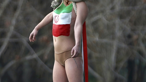 Una activista de Femen, congada de un puente de París cerca de la Torre Eiffel, para protestar contra el régimen iraní, con motivo de la visita de su presidente  Hassan Rohani. REUTERS/Charles Platiau