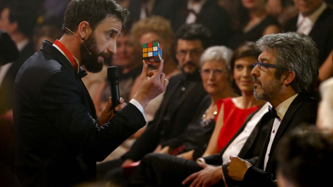 Una vez empezada la gala, Dani Rovira, el presentador, empezó a hacer de las suyas. Aquí le vemos bromeando con Ricardo Darín, cubo de Rubik por medio. / BALLESTEROS (EFE)