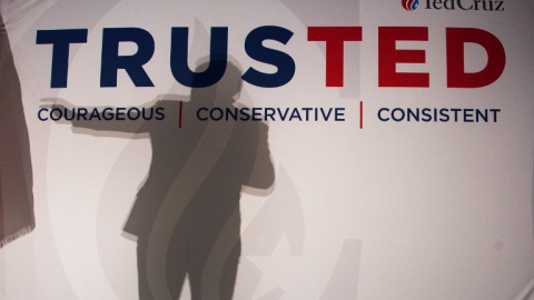 La silueta de Ted Cruz se refleja en una pancarta de su candidatura. - AFP