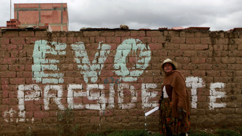 Una mujer camina frente a una pintada en apoyo a Evo Morales en las afueras de La Paz. REUTERS/David Mercado