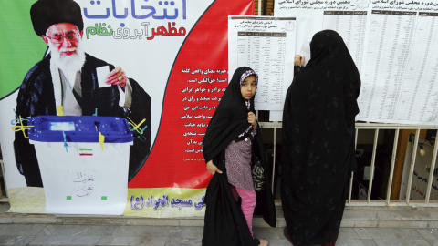 Una mujer consulta la lista de candidatos mientras espera su turno para votar en las elecciones parlamentarias y a la Asamblea de Expertos en un centro electoral en Teherán (Irán). EFE/Abedin Taherkenareh