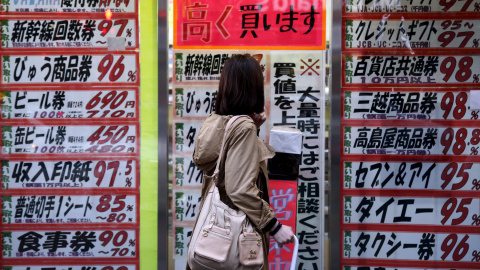 Una mujer mira a lista de precios de una tienda descuento en el barrio comercial de Tokio. REUTERS/Yuya Shino Una mujer mira a lista de precios de una tienda descuento en el barrio comercial de Tokio. REUTERS/Yuya Shino