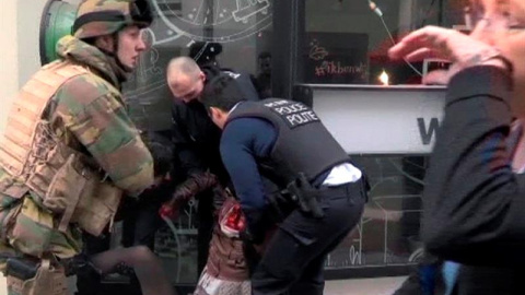 Agentes de Policía atienden a una mujer en el lugar de la explosión en la estación de metro de Malbeek, el barrio europeo de Bruselas. EFE