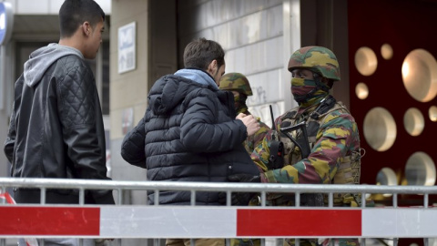 Militares belga realizan cacheos a la entrada de una estación de metro en Bruselas. - REUTERS Militares belga realizan cacheos a la entrada de una estación de metro en Bruselas. - REUTERS