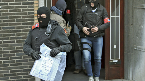 Policías enmascarados sacan objetos de un edificio de Anderlecht durante uno de sus registros tras los atentados. - REUTERS Policías enmascarados sacan objetos de un edificio de Anderlecht durante uno de sus registros tras los atentados. - REUTERS