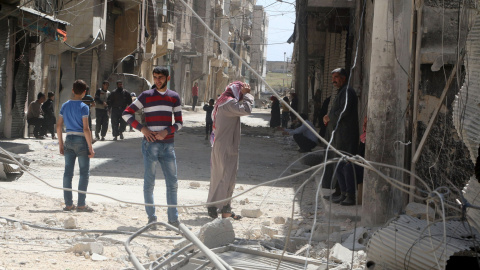 Los habitentes del barrio de al-Maysar, en Alepo, inspecciona los destrozos provocados por los bombardeos sobre las posiciones de los rebeldes sirios. REUTERS/Abdalrhman Ismail
