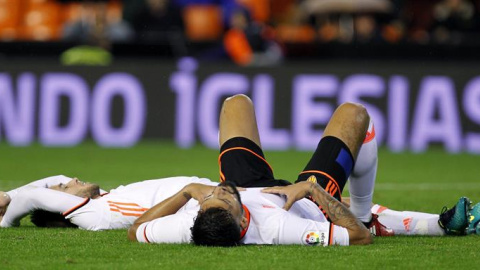 Los jugadores del Valencia Medrán (i) y Garay, al término del partido de Liga en Primera División ante el Málaga. /EFE Los jugadores del Valencia Medrán (i) y Garay, al término del partido de Liga en Primera División ante el Málaga. /EFE