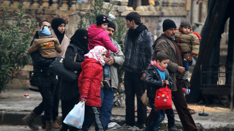 Un grupo de residentes de Alepo cargan con sus pertenencias para salir de la parte asediada de la ciudad. - REUTERS
