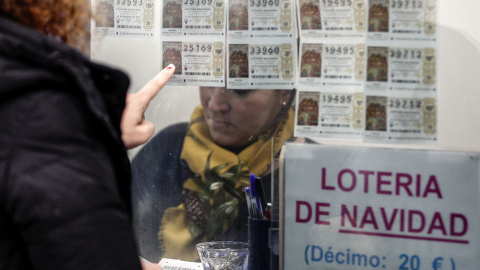 Una mujer escoge un décimo en una administración de Lotería en Valencia. EFE/Manuel Bruque Una mujer escoge un décimo en una administración de Lotería en Valencia. EFE/Manuel Bruque