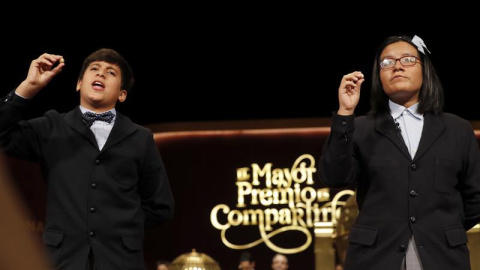 Los niños de San Ildefonso Youssef y Nicol muestran el segundo premio, dotado con 1.250.000 euros a la serie. /EFE