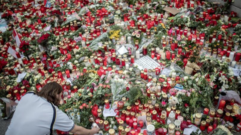 Un hombre enciende una vela en homenaje a las víctimas del atentado en Berlín. - EFE