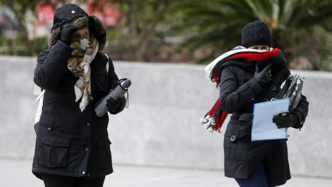 os mujeres se abrigan debido al frío y al viento durante la mañana de este jueves en Valencia/ EFE