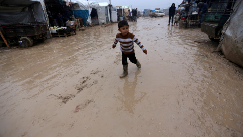 Un niño anda entre el barro en un campamento de desplazados sirios junto a la frontera con Turquía. - REUTERS Un niño anda entre el barro en un campamento de desplazados sirios junto a la frontera con Turquía. - REUTERS