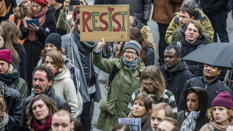 Protestas en todo el mundo. Un joven sujeta una pancarta durante una protesta contra Trump en Bruselas.- EFE