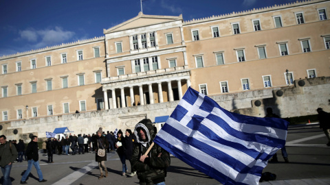 Un agricultor, con la bandera nacional griega, en la ateniense Plaza de Syntagma, donde está el Parlamento, tras una manifestación reclamando la bajada de impuestos.. REUTERS/Alkis Konstantinidis Un agricultor, con la bandera nacional griega, en la ateniense Plaza de Syntagma, donde está el Parlamento, tras una manifestación reclamando la bajada de impuestos.. REUTERS/Alkis Konstantinidis