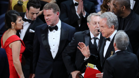 Los socios PricewaterhouseCoopers (PwC), Martha Ruiz y Brian Cullinan (a la izquierda de la imagen), conversan en el escenario de la gala de los Premios Oscar de Hollywood, mientras un regidor conversa con el actor Warren Beatty, quien sost Los socios PricewaterhouseCoopers (PwC), Martha Ruiz y Brian Cullinan (a la izquierda de la imagen), conversan en el escenario de la gala de los Premios Oscar de Hollywood, mientras un regidor conversa con el actor Warren Beatty, quien sost