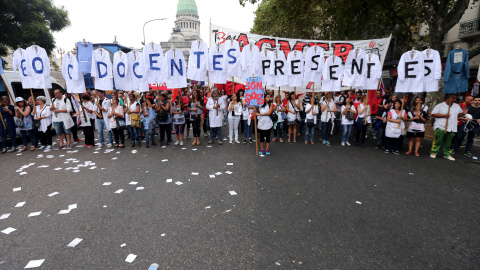 Maestros de escuelas públicas en huelga sostienen uniformes que forman las palabras "Maestros presentes" fuera del Congreso durante una protesta en Buenos Aires, Argentina. REUTERS / Marcos Brindicci