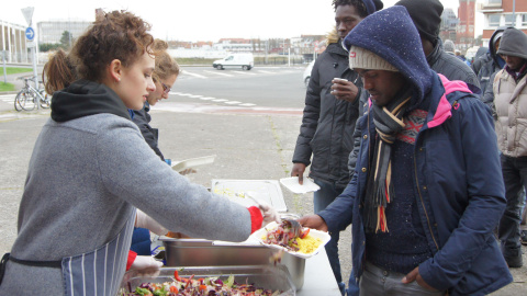 Varios refugiados esperan en la cola para recibir comida / ENRIC BONET Varios refugiados esperan en la cola para recibir comida / ENRIC BONET