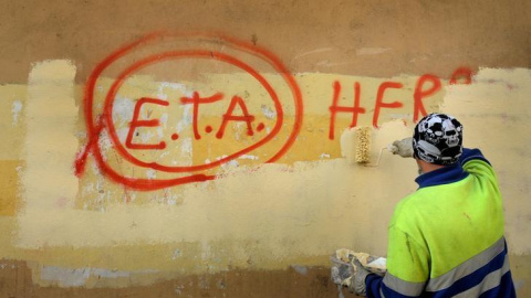 Un trabajador municipal borra un graffiti en el que se podía leer "ETA, la gente está contigo" en el pueblo vasco de Guernica, el día después que la banda terrorista anuncaria el cese de sus actividades en 2011.REUTERS/Vincent West Un trabajador municipal borra un graffiti en el que se podía leer "ETA, la gente está contigo" en el pueblo vasco de Guernica, el día después que la banda terrorista anuncaria el cese de sus actividades en 2011.REUTERS/Vincent West