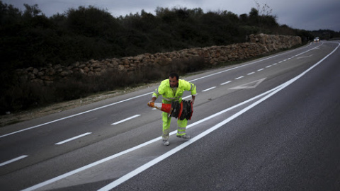 Trabajador colocando conos en una carretera de Ronda, Málaga./REUTERS Trabajador colocando conos en una carretera de Ronda, Málaga./REUTERS