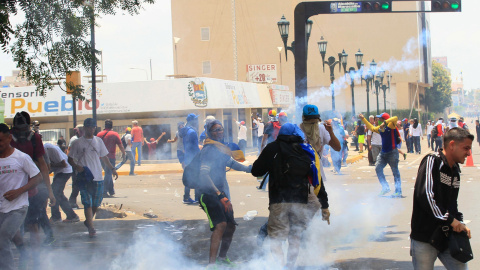 Los partidarios de la oposición chocan con las fuerzas de seguridad durante las protestas contra el presidente izquierdista Nicolás Maduro en Maracaibo, Venezuela. REUTERS / Isaac Urrutia Los partidarios de la oposición chocan con las fuerzas de seguridad durante las protestas contra el presidente izquierdista Nicolás Maduro en Maracaibo, Venezuela. REUTERS / Isaac Urrutia