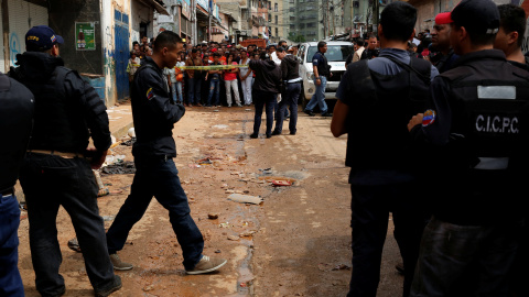 Policías e investigadores buscan evidencia frente a una panadería saqueada en Caracas. REUTERS / Carlos Garcia Rawlins Policías e investigadores buscan evidencia frente a una panadería saqueada en Caracas. REUTERS / Carlos Garcia Rawlins