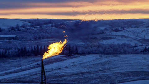 Una llamarada de gas natural en una plataforma del pozo de petróleo arde durante la puesta de sol en Watford City, Dakota del Norte. REUTERS/Andrew Cullen
