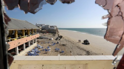 Vista general a través de un cristal roto muestra a las fuerzas del gobierno que patrullaban en la playa de Lido, tras un ataque en el restaurante junto a la playa Beach View Cafe en la capital de Somalia, Mogadiscio. REUTERS/Feisal Omar