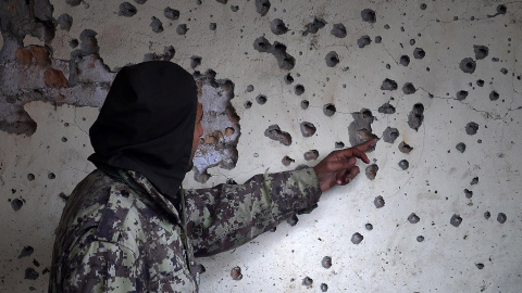 Un funcionario de seguridad paquistaní mira a una pared dañada después de un ataque suicida con bomba en las afueras de Peshawar.- A MAJEED (AFP)