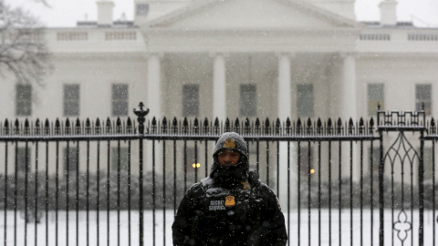 Un agente del servicio de seguridad custodia la verja de la Casa Blanca, cubierta por la nieve. /REUTERS