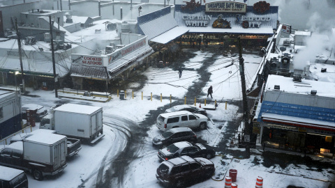 Coches aparcados y cubiertos de nieve frente a un centro comercial en Washington. /REUTERS