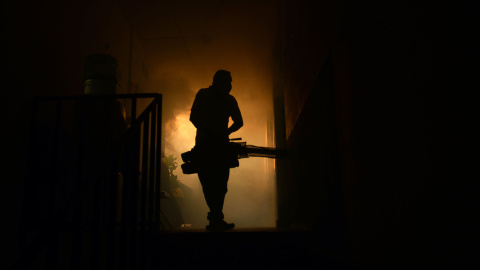 Un empleado del Ministerio de Sanindad fumiga una casapara evitar la propagación del virus Zika, en Soyapango, a 6 km al este de San Salvador. AFP PHOTO / Marvin RECINOS