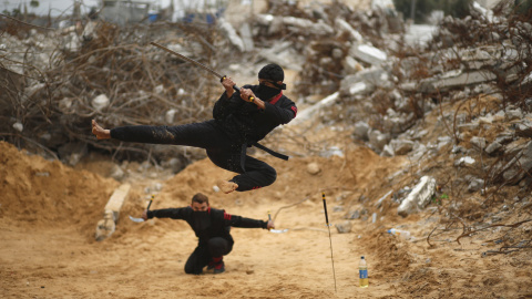 Jóvenes palestinos salta con una espada al estilo del ninja en el norte de la Franja de Gaza. REUTERS/Mohammed Salem