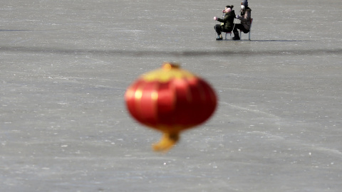 Personas desplazandose en trineos improvisados en un lago congelado en Pekín. REUTERS/Damir Sagolj