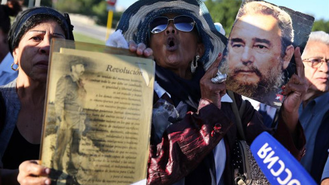 Dos mujeres muestran retratos del fallecido líder cubano Fidel Castro, durante un homenaje póstumo en la Plaza de la Revolución de La Habana (Cuba). EFE