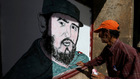 Un artista pinta un retrato de Fidel Castro enfrente de una tienda en la Habana. REUTERS