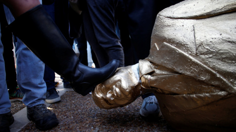 Una mujer patea la estatua satírica derruida de Netanyahu. REUTERS/Baz Ratner