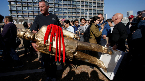 Un hombre sujeta la estatua satírica contra el primer ministro de Israel Benjamin Netanyahu. REUTERS/Baz Ratner