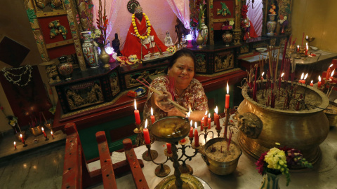 Una mujer de la comunidad china enciende una vela mientras reza en el templo de Calcuta, India. REUTERS/Rupak De Chowdhuri