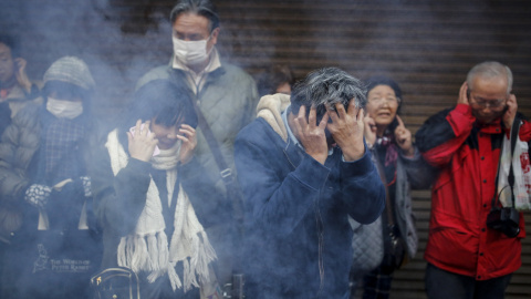 Unos asistentes de la celebración del Año Nuevo del Mono de Fuego Chino se tapan los oídos ante el estruendo ruido de los petardos, en el barrio de Chinatown de Yokohama, al sur de Tokio, Japón. REUTERS/Thomas Peter