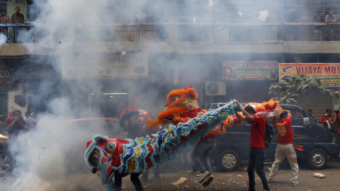 Miembros de la comunidad china actúan en medio de los cohetes en las celebraciones del Año Nuevo Chino de Calcuta, India. REUTERS/Rupak De Chowdhuri