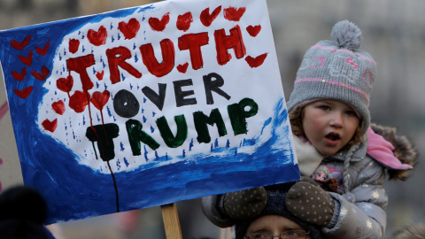Una niña en Praga sostiene una pancarta en la que se puede leer: 'Truth over Trump'.- REUTERS