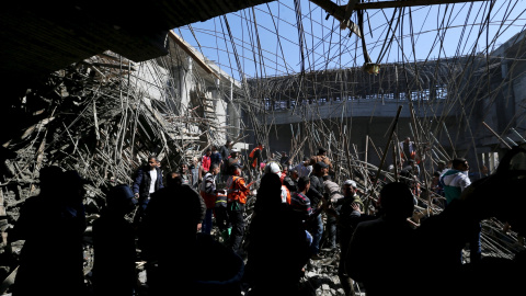 La gente se reúne mientras miembros de la defensa civil palestina hacen una búsqueda de víctimas después de que un techo colapsara en la construcción de la Universidad de al-Aqsa en Khan Younis, en el sur de la Franja de Gaza, 15 de febrero